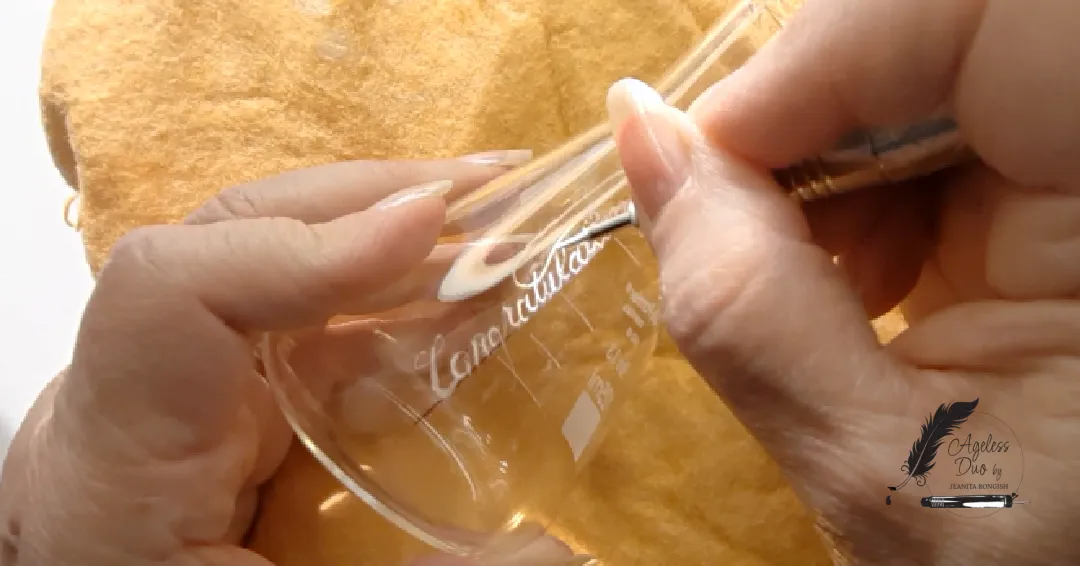 Jeanita hand-engraving the word “Congratulations” onto a laboratory beaker