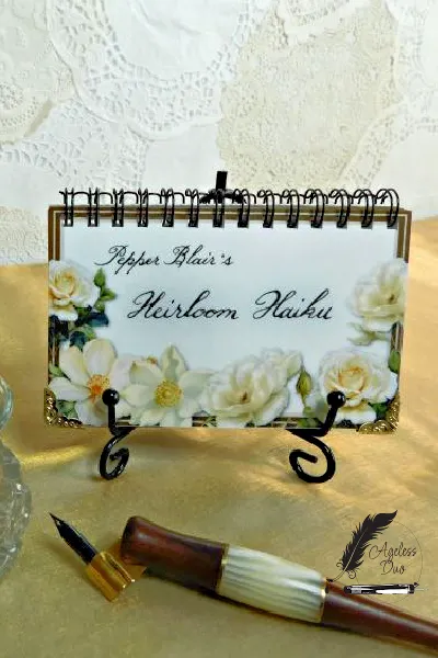 Desktop Haiku Book — Calligraphic Poetry Spiral-bound desktop poetry book featuring Jeanita's calligraphy displayed on a wrought iron stand